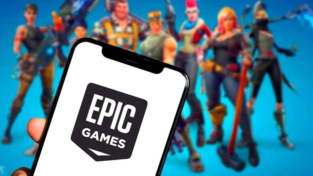 Pessoa segurando celular com logotipo da Epic Games e personagens de Fortnite ao fundo