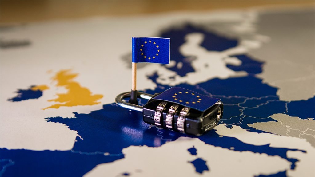 Cadeado com miniatura de bandeira da União Europeia sobre mapa da Europa para ilustrar Lei dos Serviços Digitais DSA
