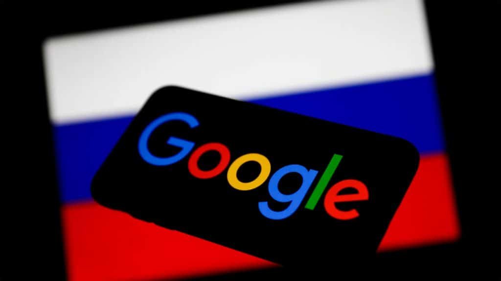 Celular com imagem da logomarca do Google aberta e ao fundo tablet com imagem da bandeira da Rússia aberta