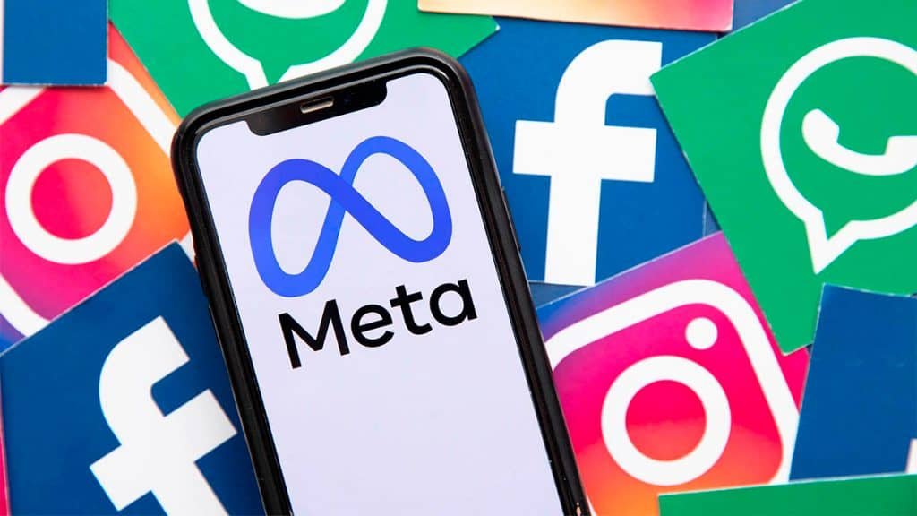 Celular com logomarca da Meta e ícones do Instagram Facebook e WhatsApp ao fundo