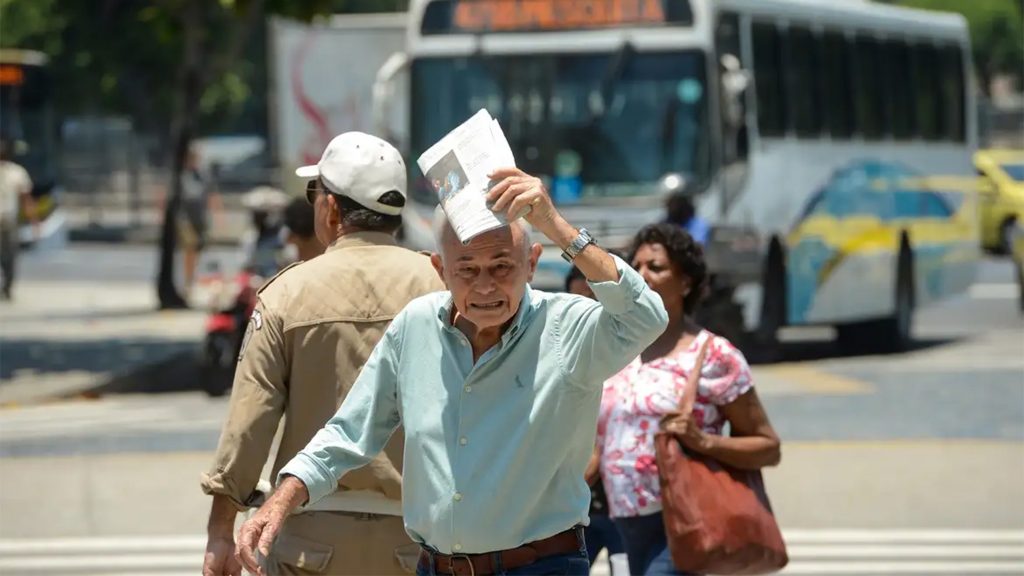 Idoso protegendo cabeça contra o sol usando jornal dobrado em dia quente