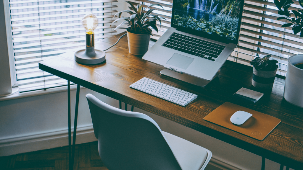 imagem mostra um home office com notebook mouse e teclado