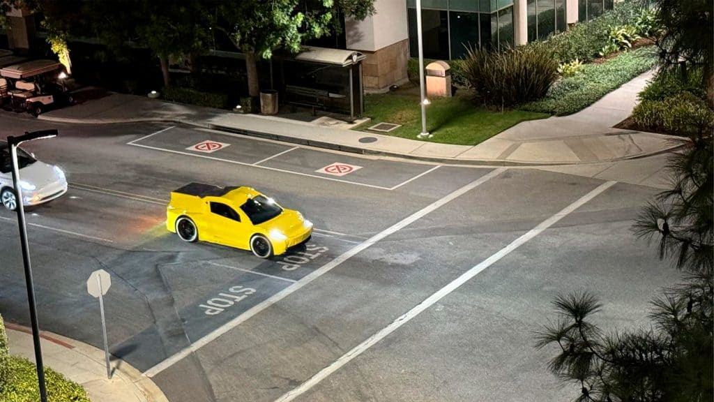 Carro amarelo pequeno visto de longe que pode ser robotáxi da Tesla