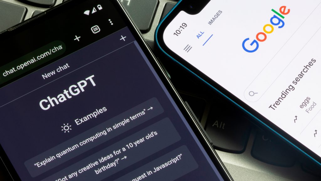 Celulares com ChatGPT e Google abertos em cima de teclado de notebook