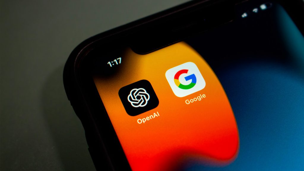Ícones da OpenAI e do Google um do lado do outro em tela inicial do iPhone